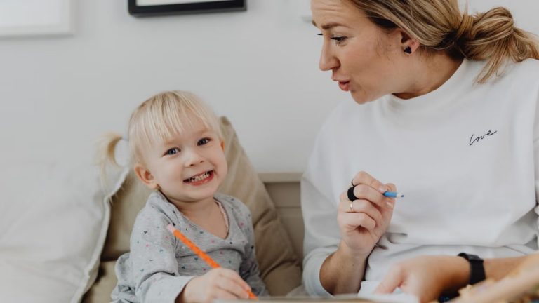 A joyful child and an adult engaged in learning at home, fostering creativity and connection.