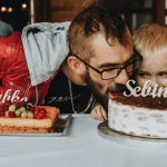 Father and child enjoying a birthday celebration with delicious cakes and festive decorations.