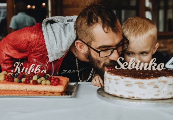 Father and child enjoying a birthday celebration with delicious cakes and festive decorations.