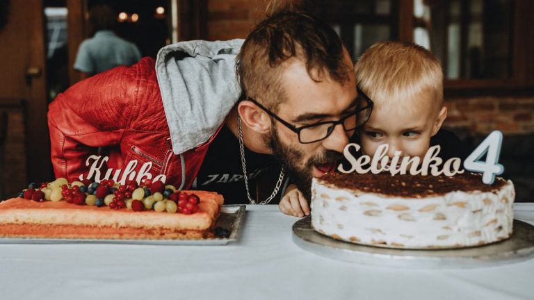 Father and child enjoying a birthday celebration with delicious cakes and festive decorations.